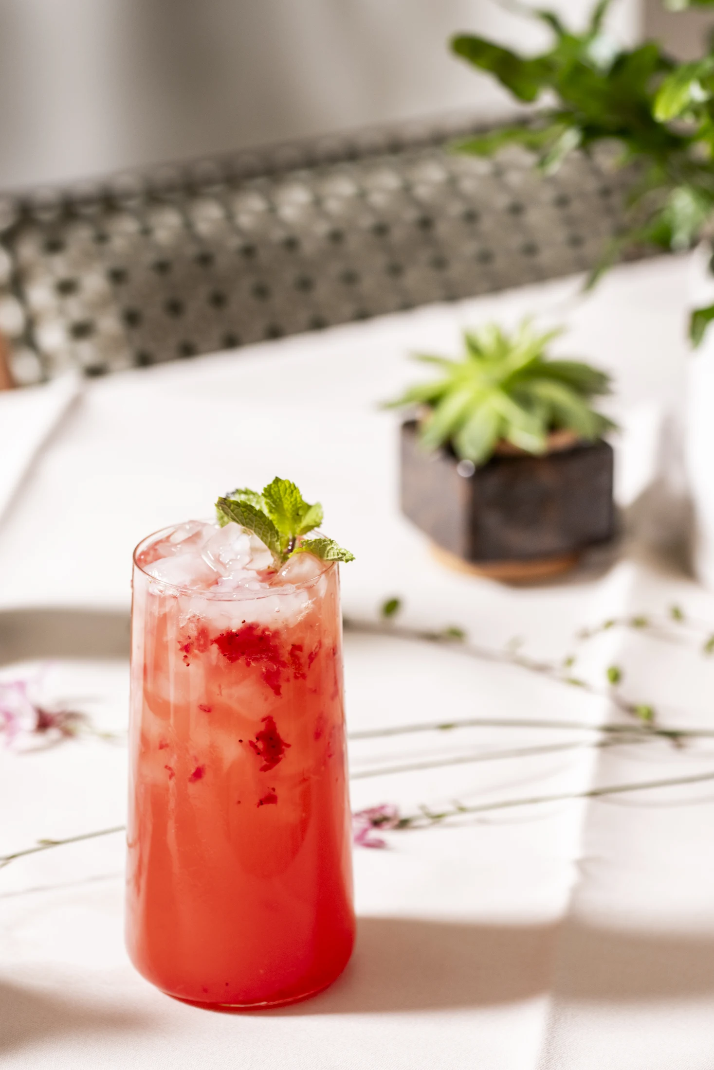 Erfrischender Sakura-Lychee-Hausdrink mit Crushed Ice, Beeren und Minze
